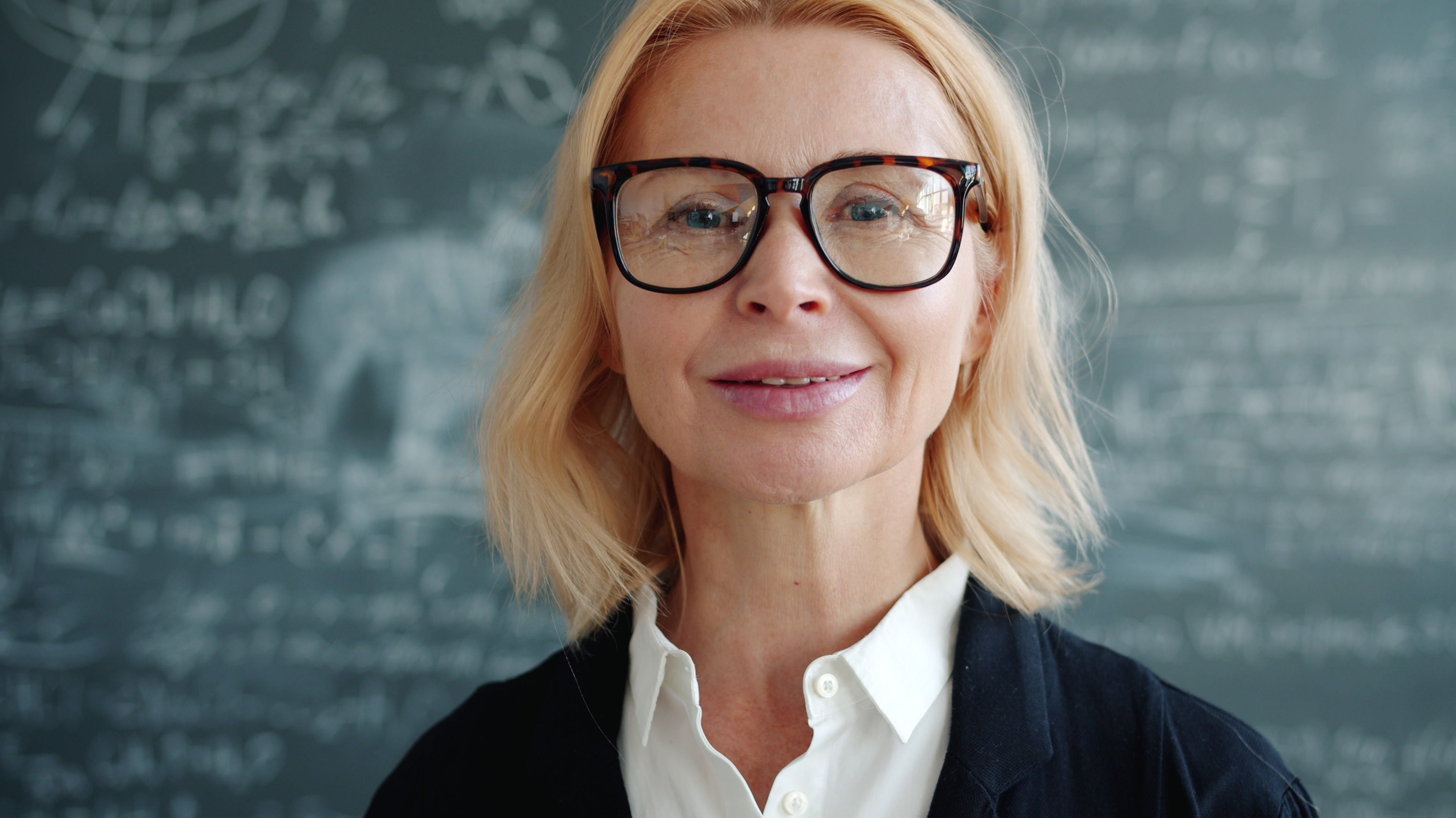 A faculty member in front of a chalkboard